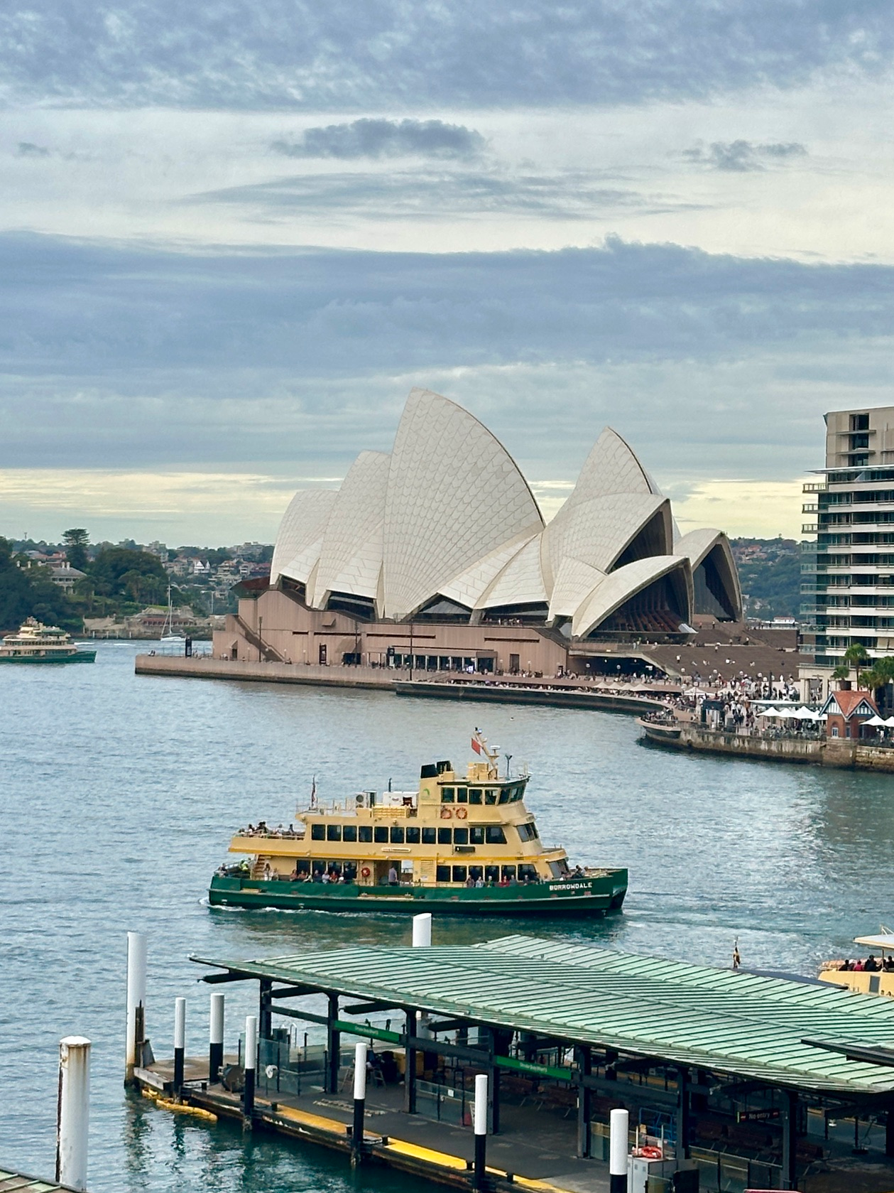 Yellow and green ferry in Sydney Harbour with Opera House