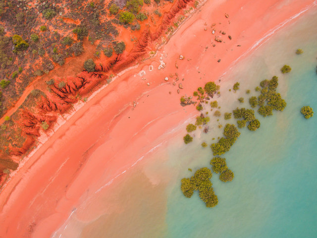 Aerial view of Roebuck Bay’s red shoreline and turquoise water near Broome, Western Australia
